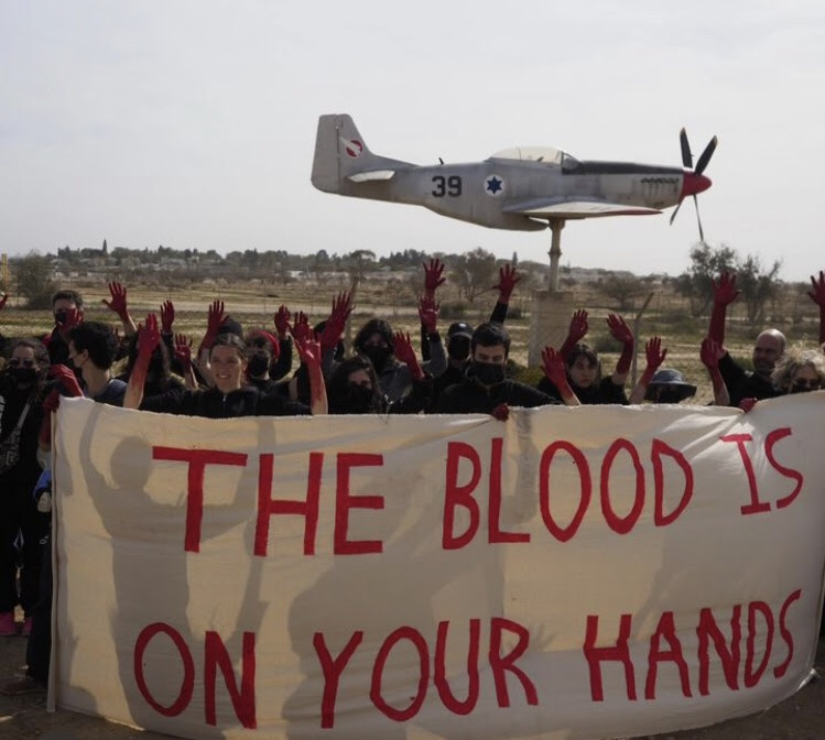 A group of people holding a banner with a plane in the background
AI-generated content may be incorrect.