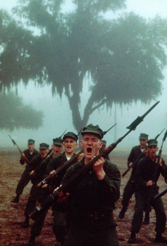 A group of soldiers marching with guns

Description automatically generated