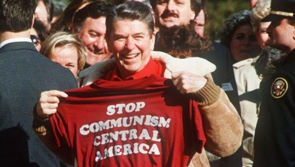 A person holding a red shirt with a group of people behind him

AI-generated content may be incorrect.