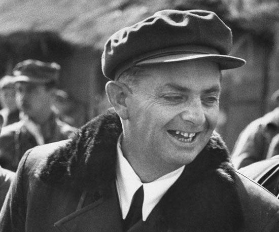 A person in a hat smiling
Description automatically generated