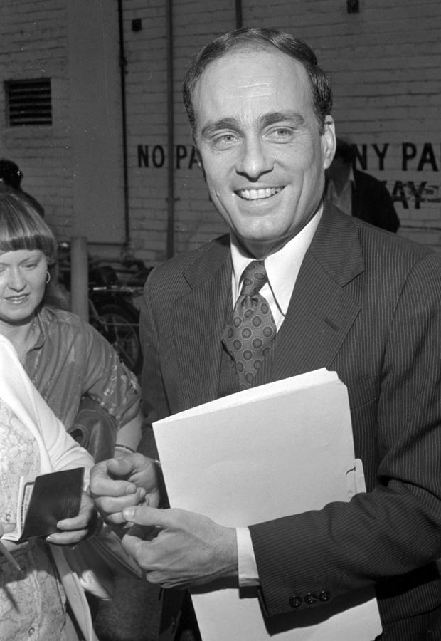 A person in a suit holding papers
AI-generated content may be incorrect.