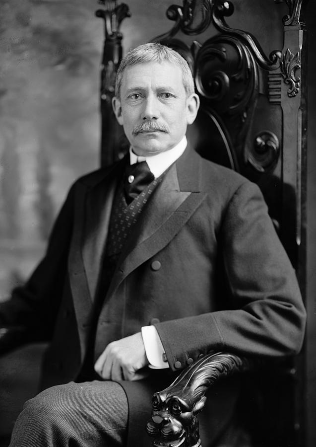 A person in a suit sitting in a chair
AI-generated content may be incorrect.