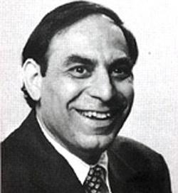 A person in a suit smiling

Description automatically generated
