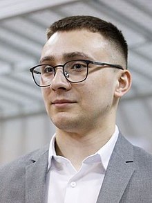 A person wearing glasses and a suit
AI-generated content may be incorrect.
