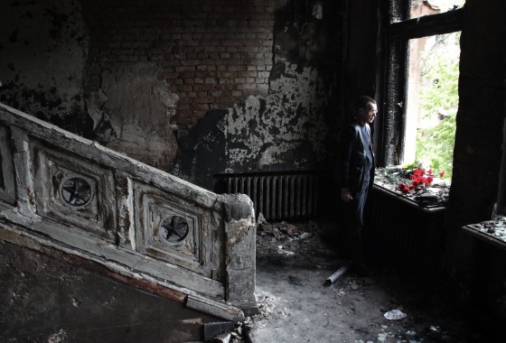 Image: A man lays flowers inside the burnt trade union building in Odessa