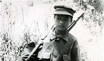 A child in uniform holding a rifle
Description automatically generated