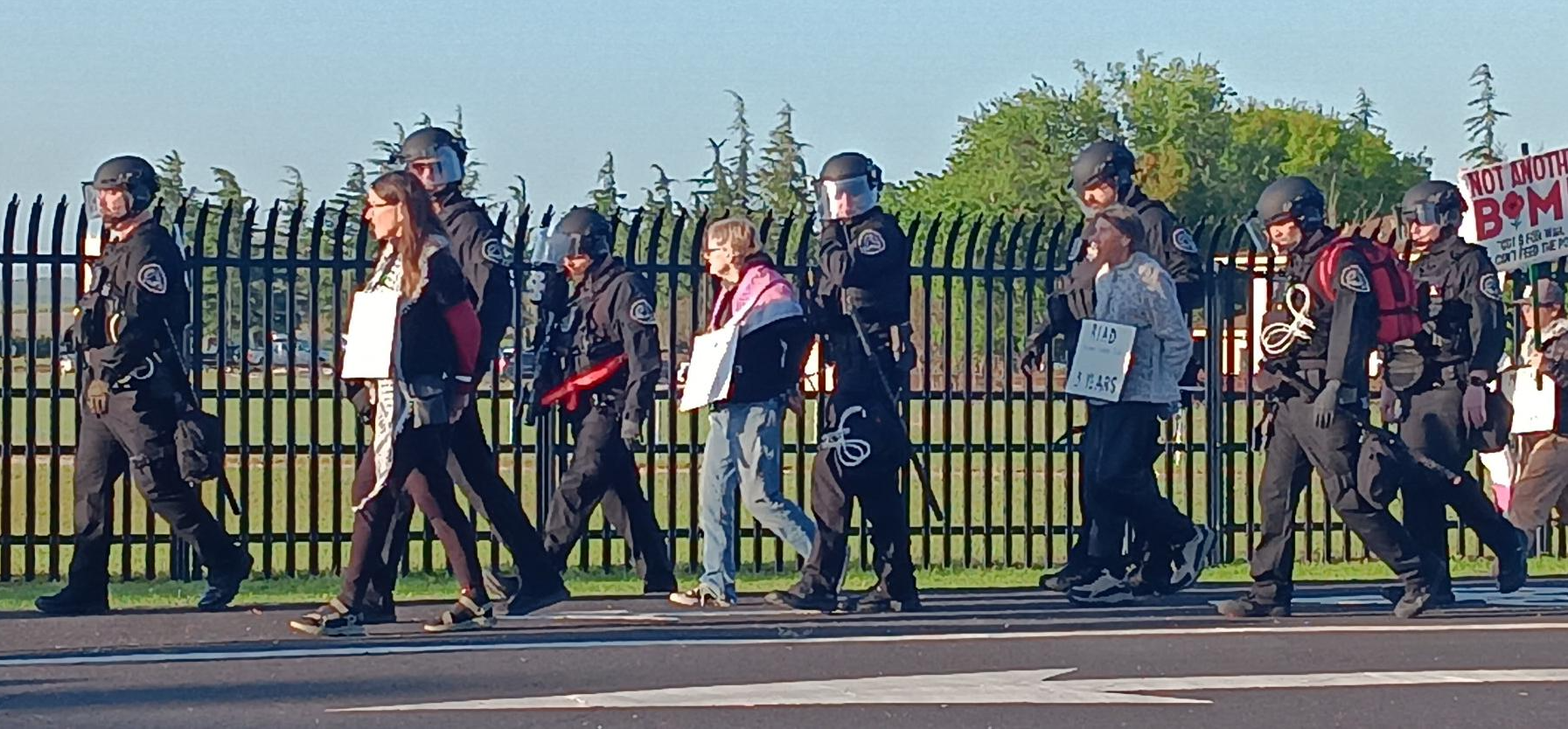 A group of people in riot gear walking on the street

AI-generated content may be incorrect.