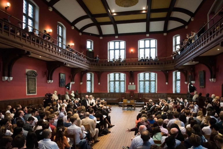 A group of people sitting in a room
AI-generated content may be incorrect.