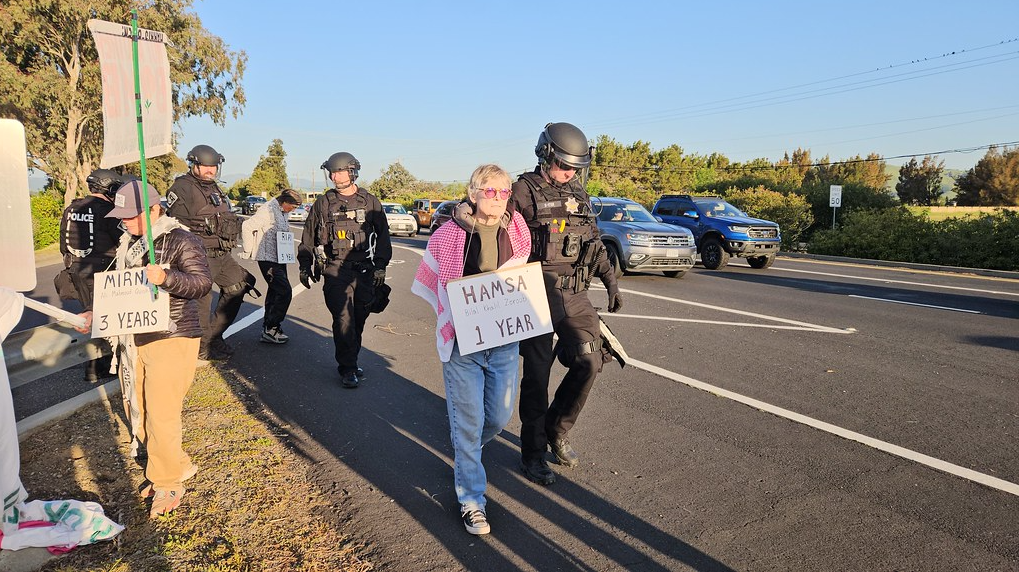 A person carrying a sign with police officers

AI-generated content may be incorrect.