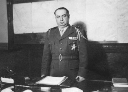 A person in a military uniform standing at a desk
AI-generated content may be incorrect.
