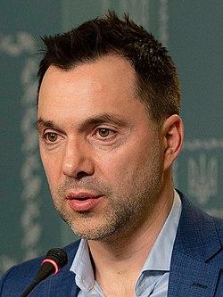 A person in a suit speaking into a microphone

AI-generated content may be incorrect.