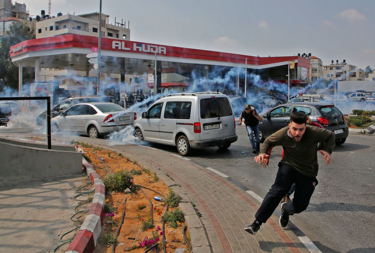 Palestinians run away from tear gas shot at them by Israeli forces during a protest in Ramallah, in the West Bank, on Tuesday.