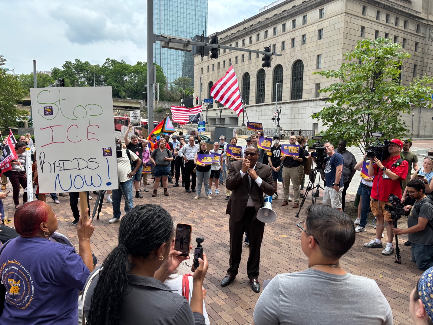 A group of people holding signs and a microphone
AI-generated content may be incorrect.