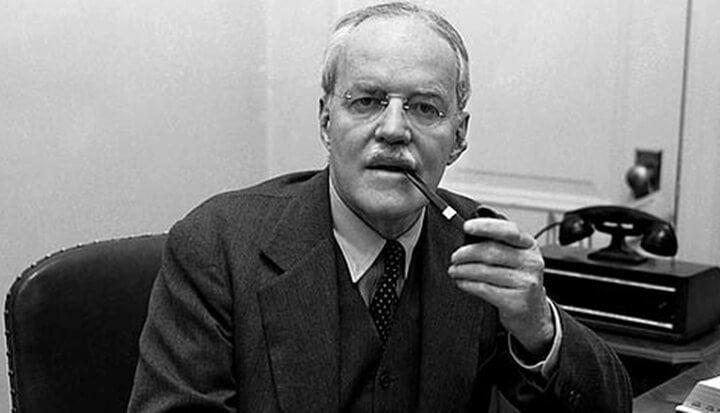 A person in a suit smoking a pipe

AI-generated content may be incorrect.