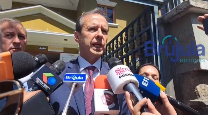 A person in a suit speaking into microphones
AI-generated content may be incorrect.