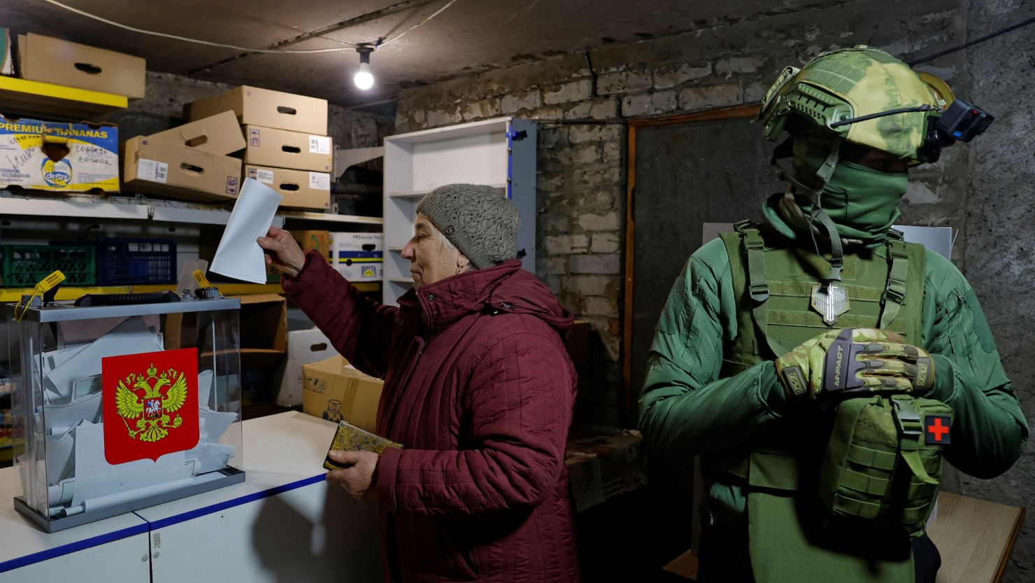 A woman casts her vote at a mobile ballot box during the Russian presidential election, in the basement of a destroyed apartment building in Avdiivka, in the Donetsk region of Russian-controlled Ukraine, on March 16.