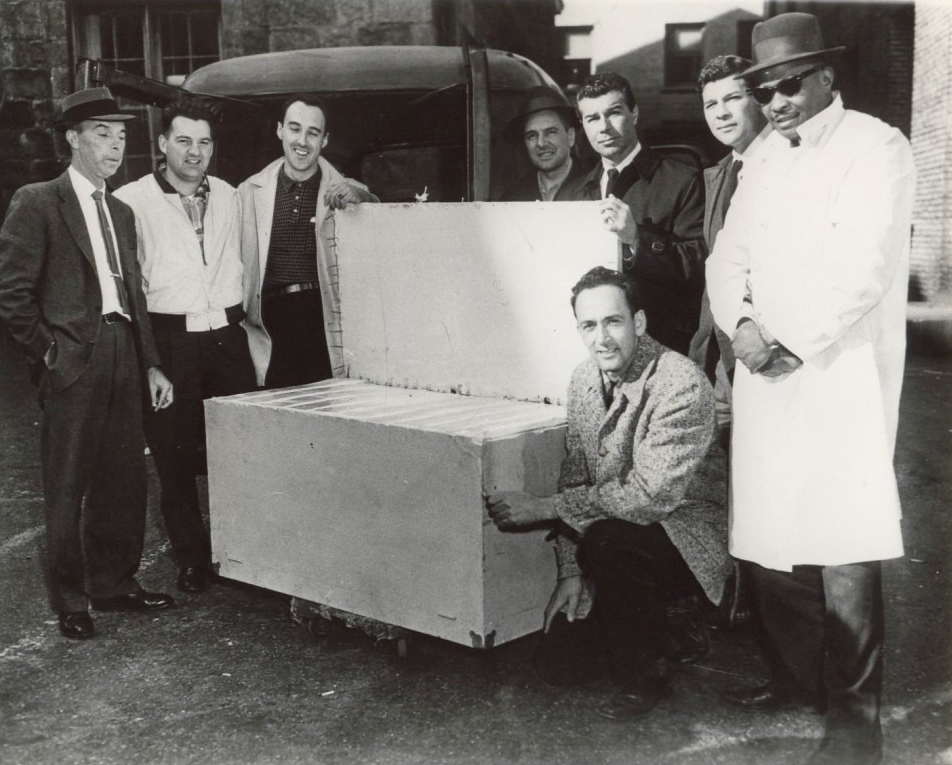 A group of men holding a box

AI-generated content may be incorrect.
