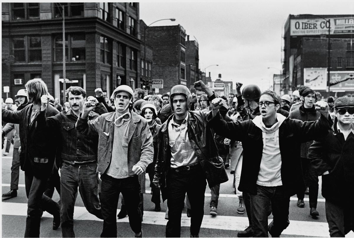A group of people marching in a street
Description automatically generated
