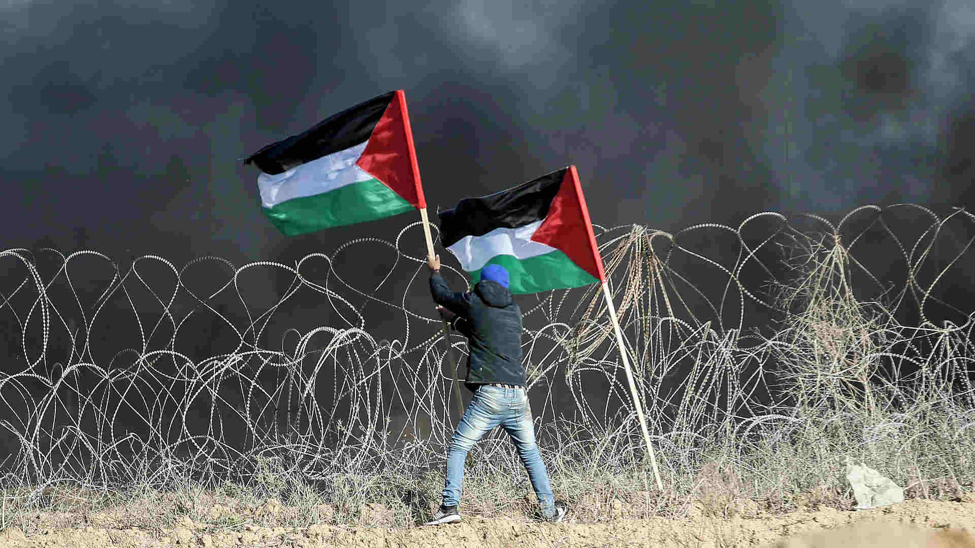 A person holding two flags

AI-generated content may be incorrect.