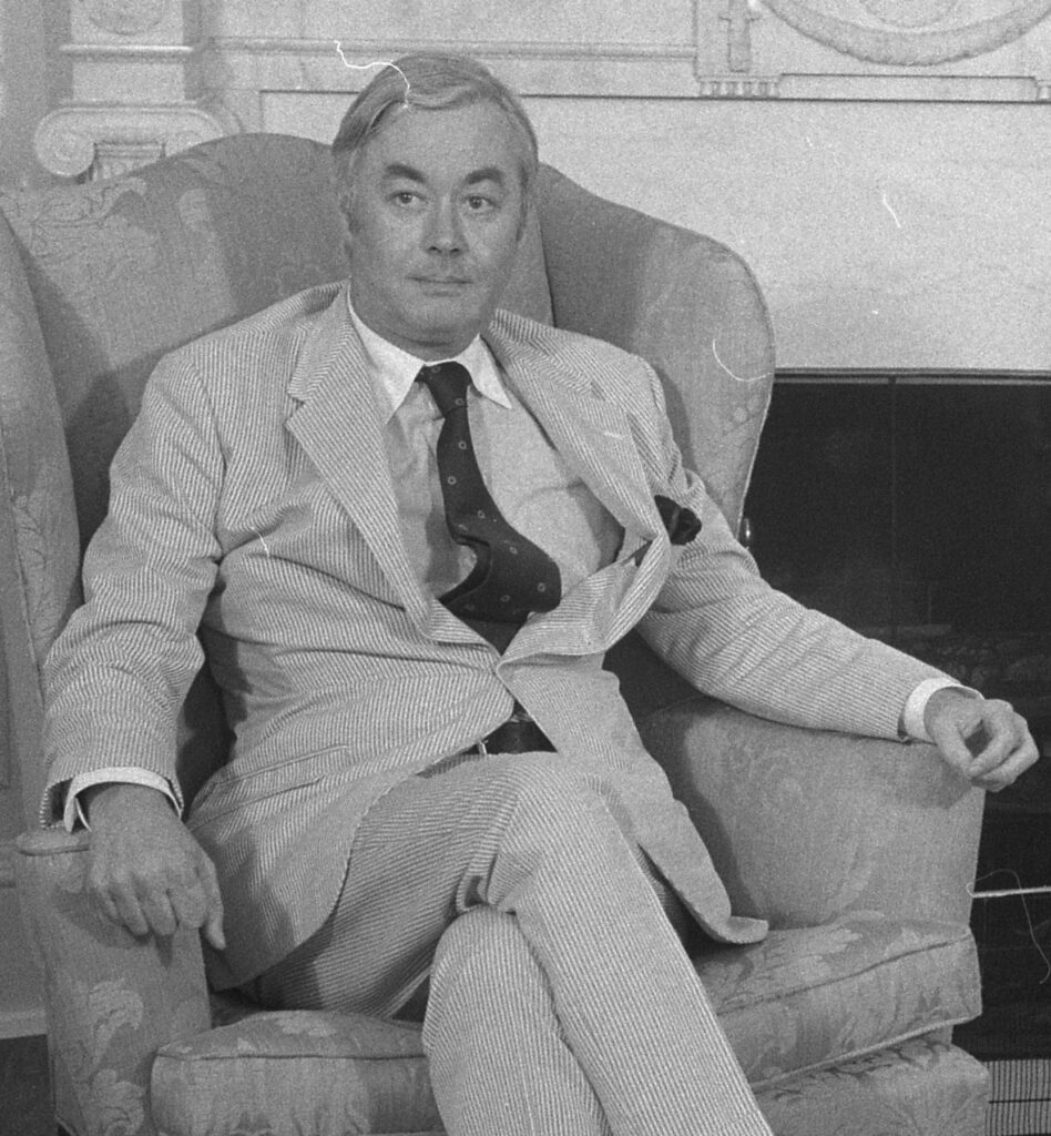 A person in a suit and tie sitting in a chair
AI-generated content may be incorrect.