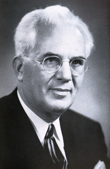 A person wearing glasses and a suit

AI-generated content may be incorrect.