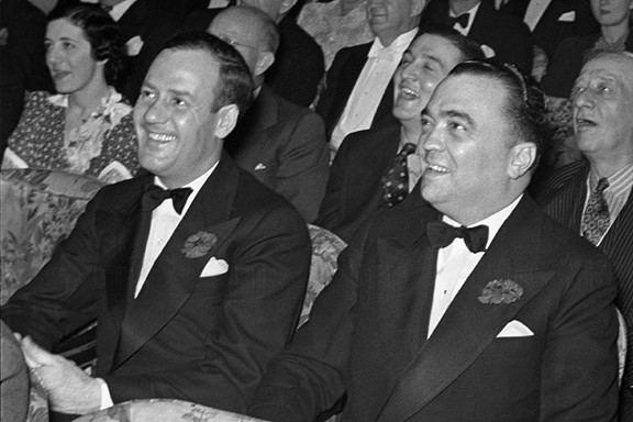 A group of men in suits smiling AI-generated content may be incorrect.