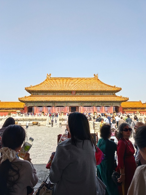 A group of people standing in front of Forbidden City AI-generated content may be incorrect.