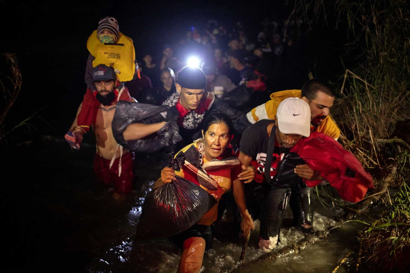 A group of people walking through water
AI-generated content may be incorrect.