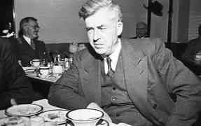 A person in a suit sitting at a table
AI-generated content may be incorrect.