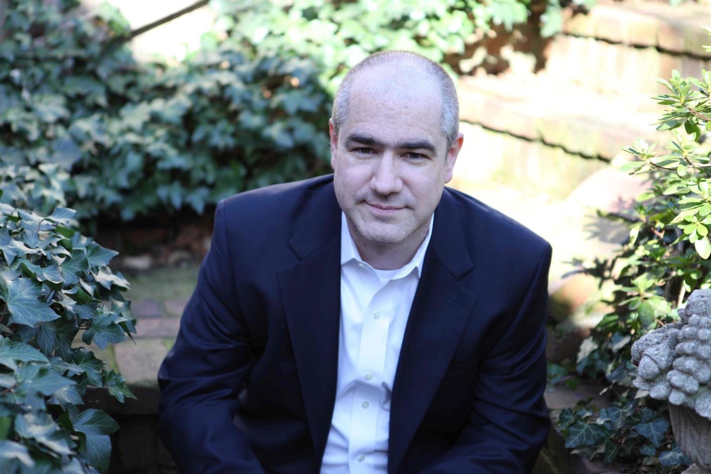 A person in a suit sitting in a garden
AI-generated content may be incorrect.