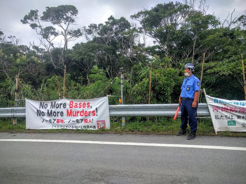A person standing on the side of the road with a sign
Description automatically generated