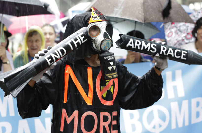 A person wearing a gas mask holding two signs

AI-generated content may be incorrect.
