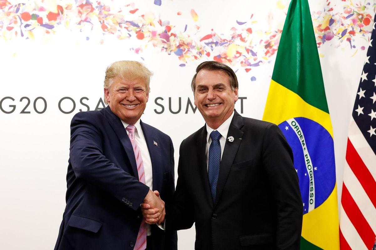 Two men shaking hands in front of a flag
AI-generated content may be incorrect.