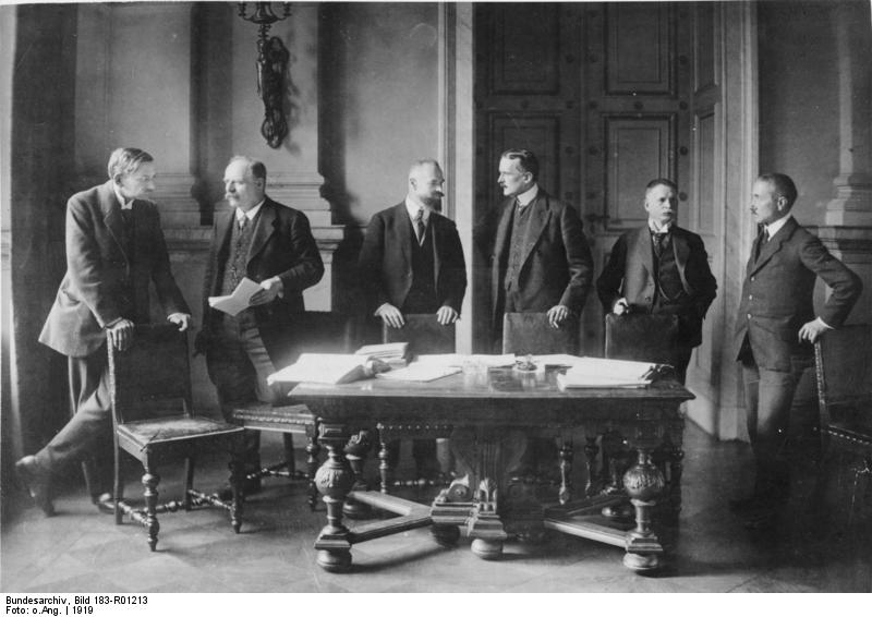 A group of men standing around a table

AI-generated content may be incorrect.