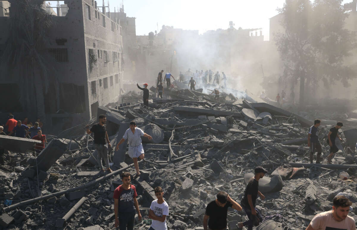 A group of people standing in a rubble area

AI-generated content may be incorrect.