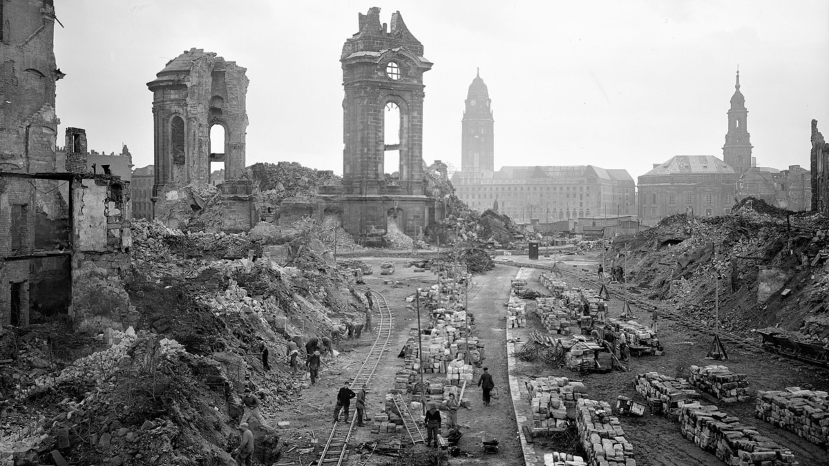 A large destroyed building with a few people

AI-generated content may be incorrect.