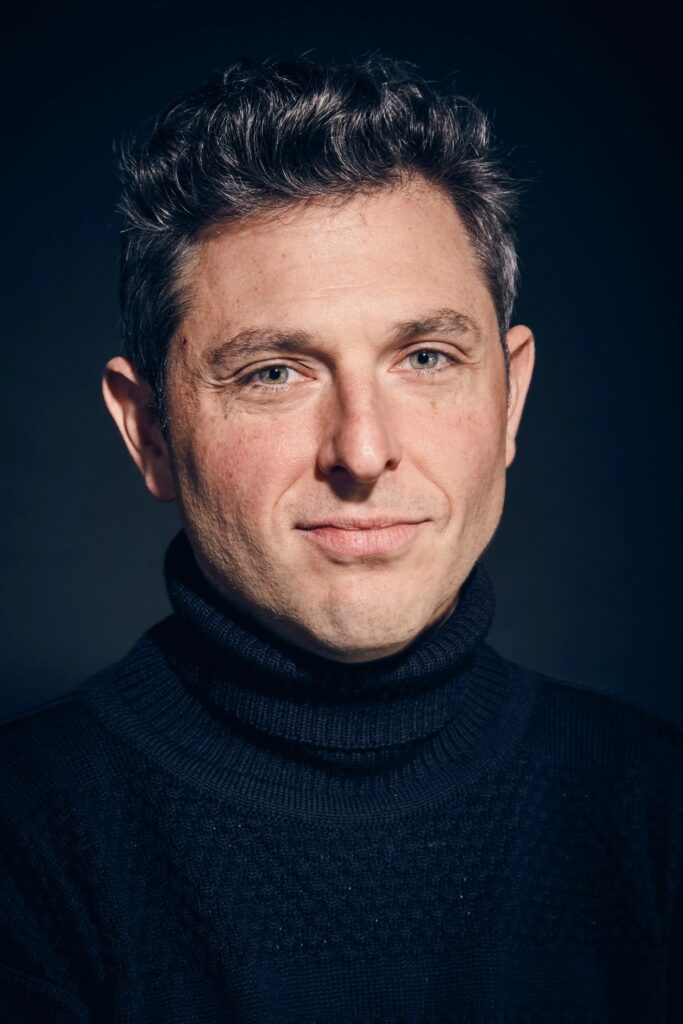A person in a black turtleneck sweater

AI-generated content may be incorrect.