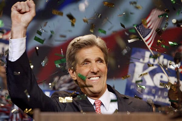 A person in a suit and tie with his hands up

AI-generated content may be incorrect.