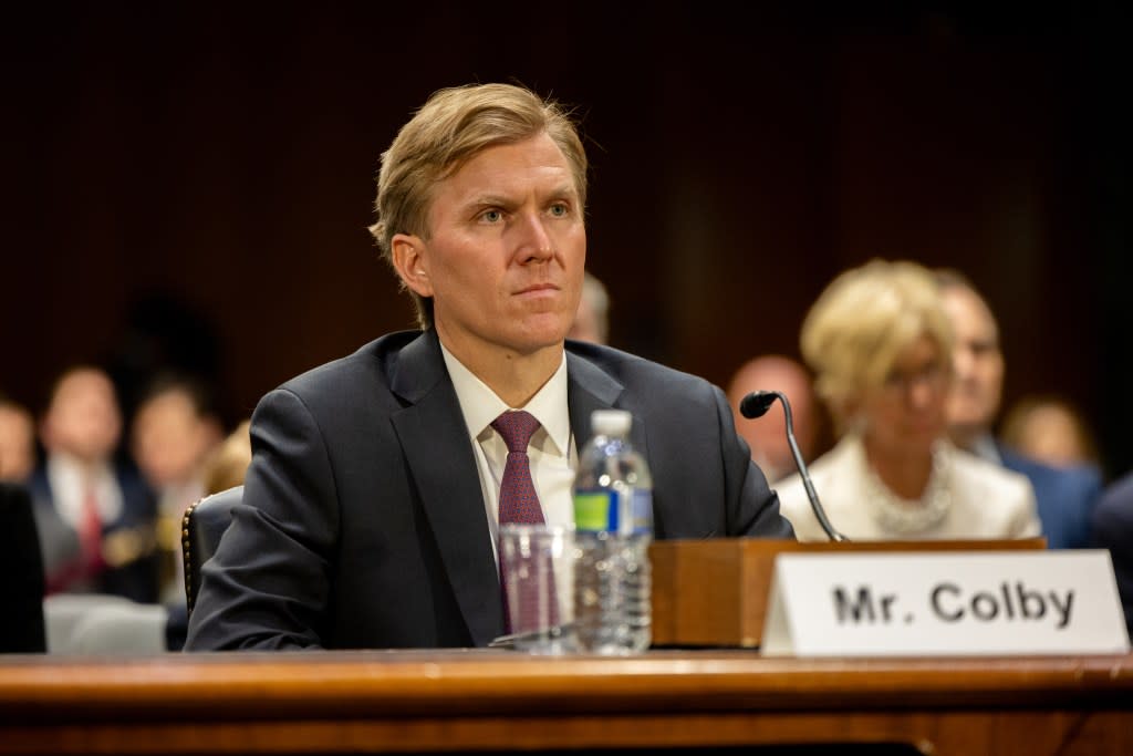 A person in a suit sitting at a desk

AI-generated content may be incorrect.