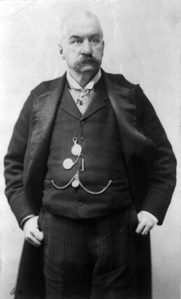 A person in a suit with a medal on his waist

AI-generated content may be incorrect.