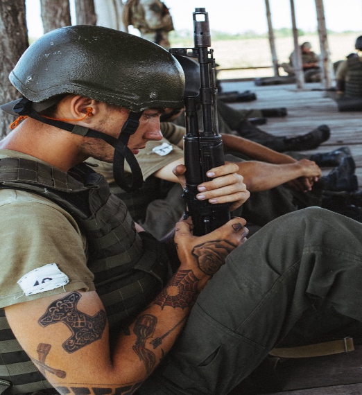 A person in military uniform holding an object AI-generated content may be incorrect.