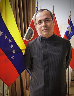 A person standing in front of flags
AI-generated content may be incorrect.