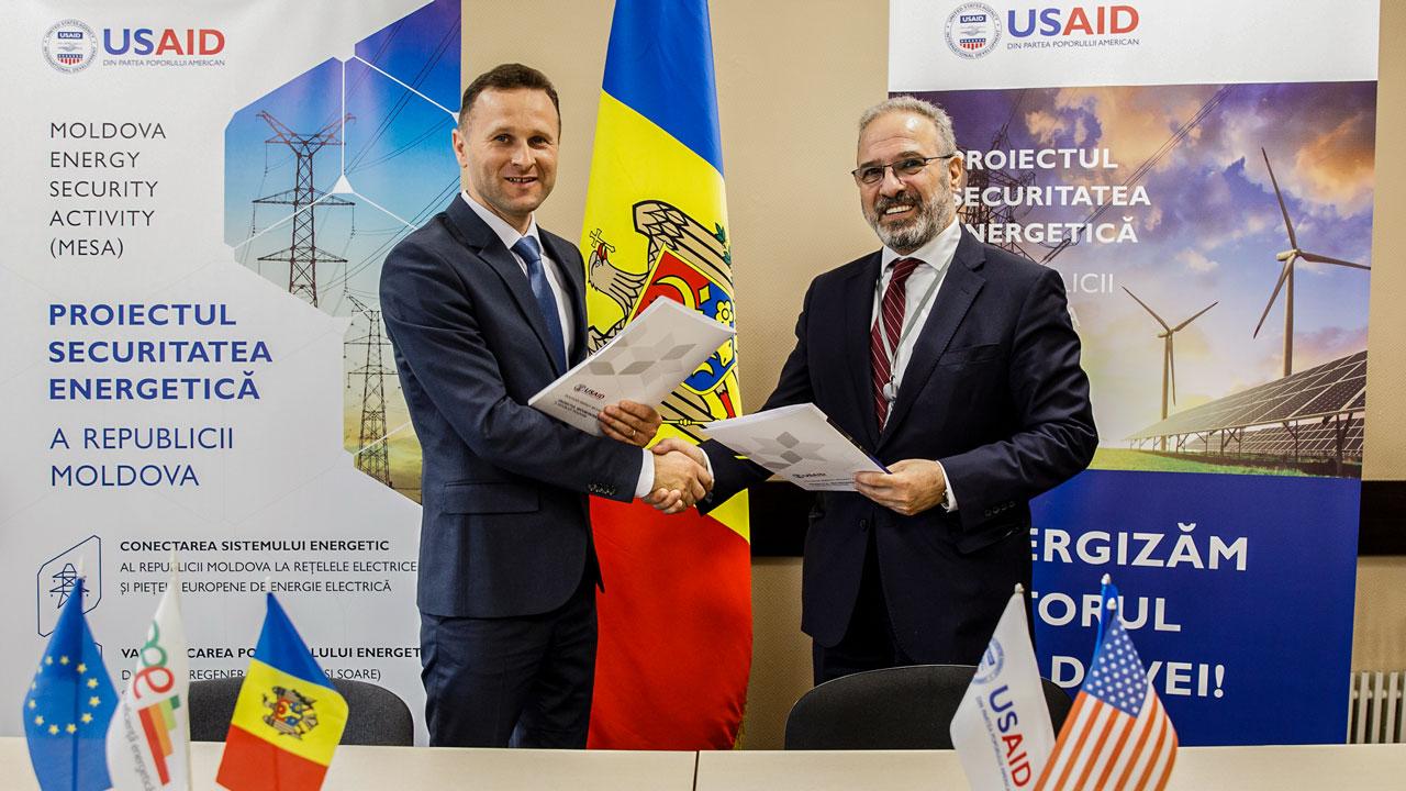 Representatives from Tetra Tech and Moldova’s Energy Efficiency Agency shaking hands at a cooperation agreement meeting related to enhancing energy efficiency in public buildings