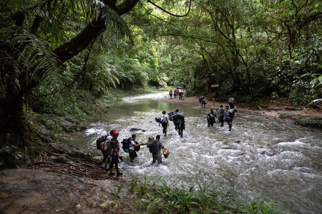 A group of people crossing a river AI-generated content may be incorrect.
