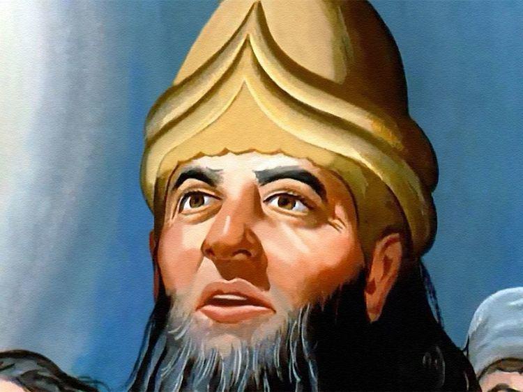 A person with a beard wearing a gold hat

Description automatically generated