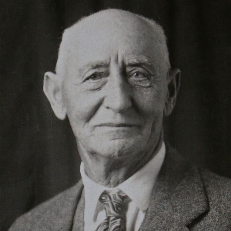 An old person in a suit and tie<br><br>AI-generated content may be incorrect.