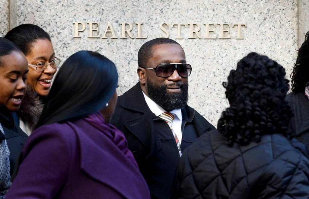 Michael Thomas, a correctional officer, leaves court surrounded by supporters.