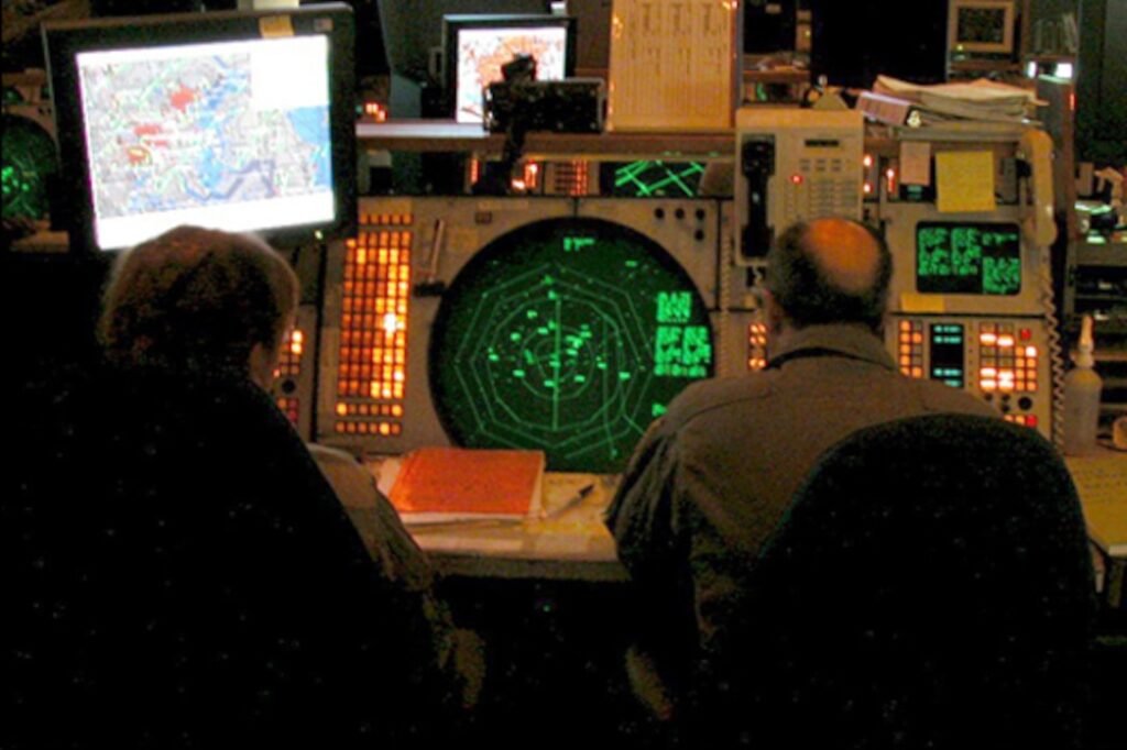 The Northeast Air Defense Sector operations floor after 9/11. Above the large green radar scope is the NORAD contingency suite that was installed immediately after 9/11 to provide radar data of the entire country. Photo by Master Sgt. Stacia Rountree, Eastern Air Defense Sector