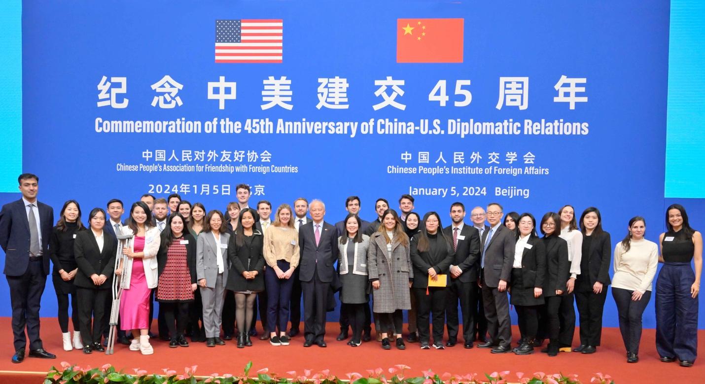 A group of people standing in front of a blue sign

AI-generated content may be incorrect.