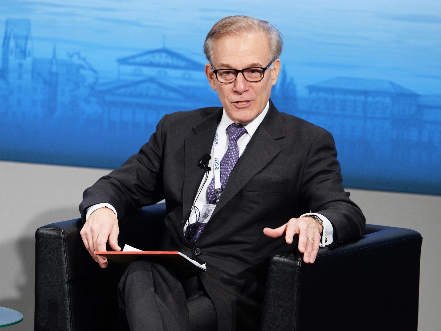 A person in a suit and tie sitting in a chair
AI-generated content may be incorrect.